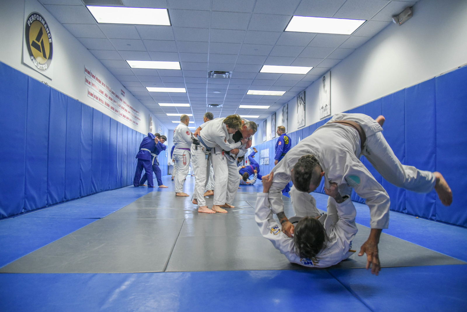 Adults training Brazilian Jiu-Jitsu in the main training hall at Performance Jiu-Jitsu Academy in Fair Lawn, NJ
